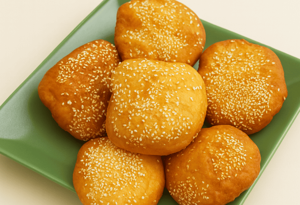 Golden-brown banh tieu with their characteristic hollow, balloon-like shape